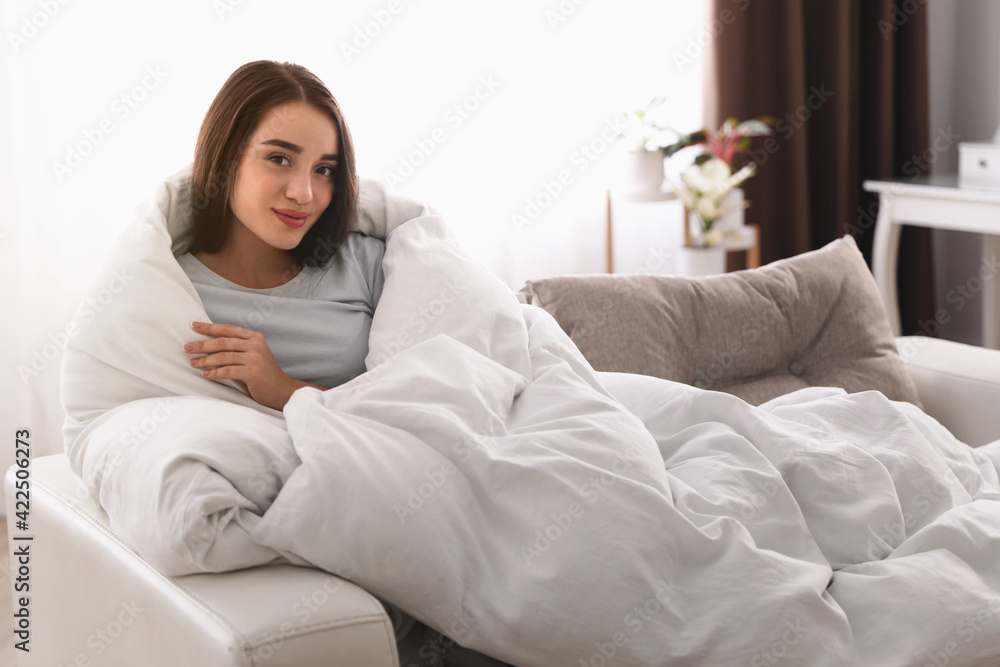 Woman covered in blanket resting on sofa, space for text Woman covered in blanket resting on sofa, space for text
