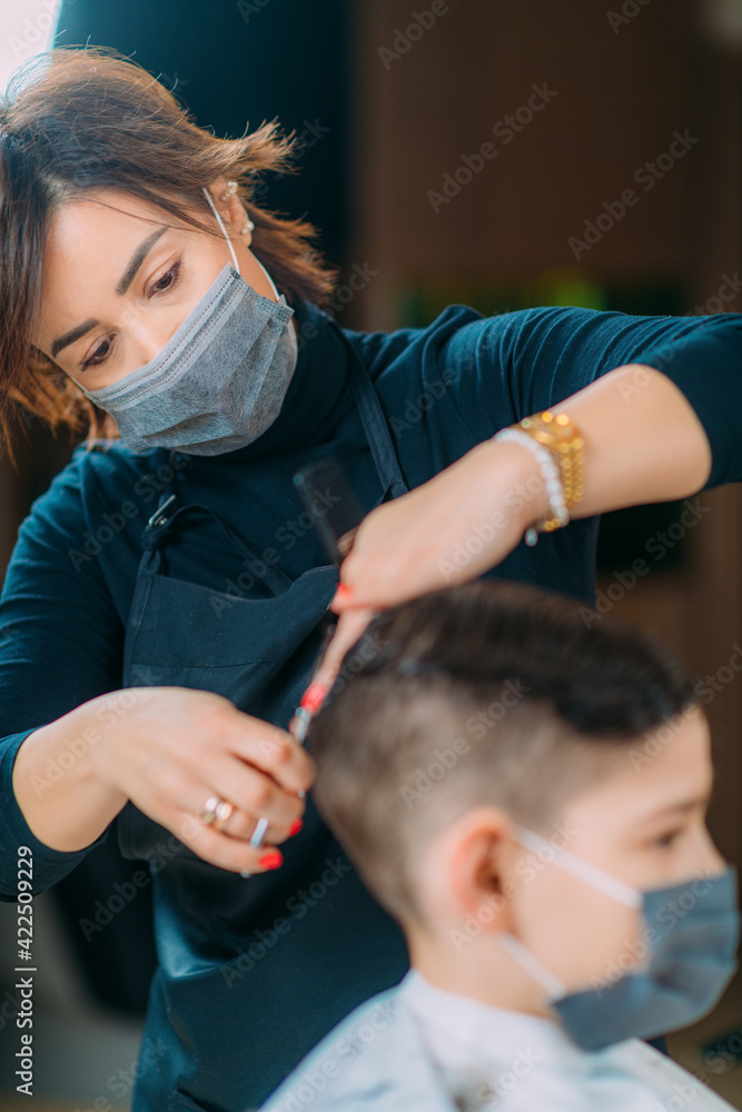 Cutting Boy's Hair in Beauty Salon, Wearing protective Mask, Close-up Cutting Boy's Hair in Beauty Salon, Wearing protective Mask, Close-up