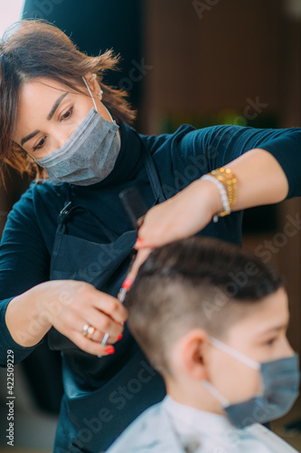 Cutting Boy's Hair in Beauty Salon, Wearing protective Mask, Close-up