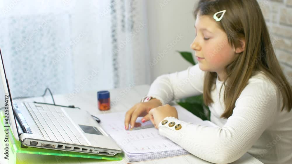 Young girl follows school lessons connected to pc at home Young girl follows school lessons connected to pc at home