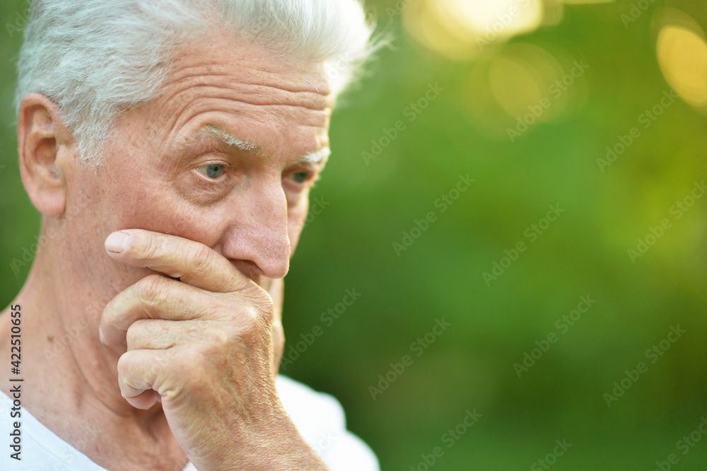 portrait of thinking senior man in park portrait of thinking senior man in park