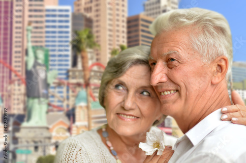 happy senior couple hugging against city skyline