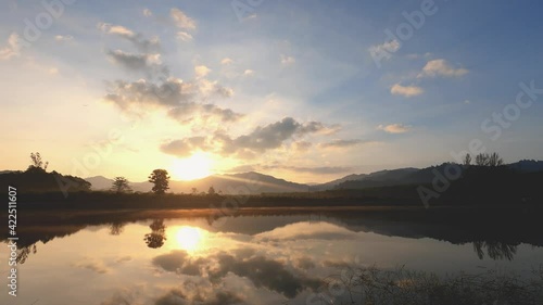 Wallpaper Mural beautiful sunrise sky in spring morning at the lake. bright sunshine over blue sky and reflection of trees and orange color of morning sun in the water surface. clouds moving fast in wide space.  Torontodigital.ca