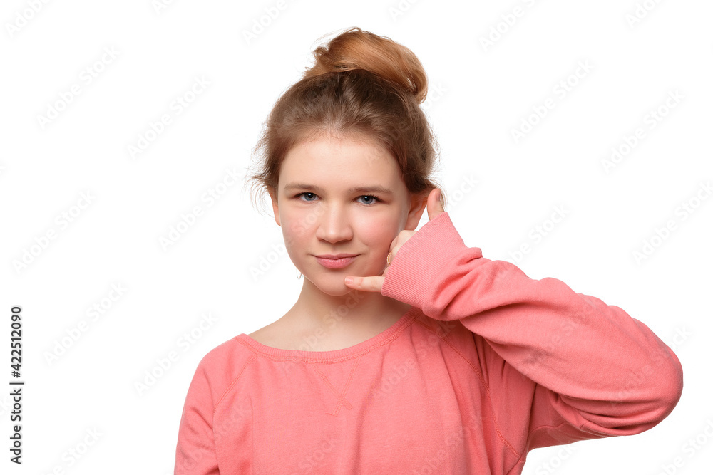 close up teen girl imitates telephone conversation, keeps hand near ear as if holding mobile phone, saying call me close up teen girl imitates telephone conversation, keeps hand near ear as if holding mobile phone, saying call me