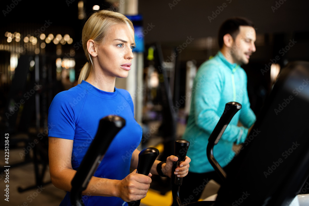 Happy people working out on treadmills in the gym Happy people working out on treadmills in the gym