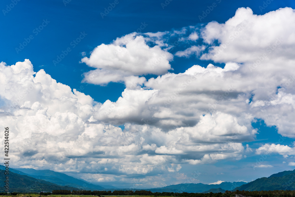 Rolling mountains with blue sky and clouds background