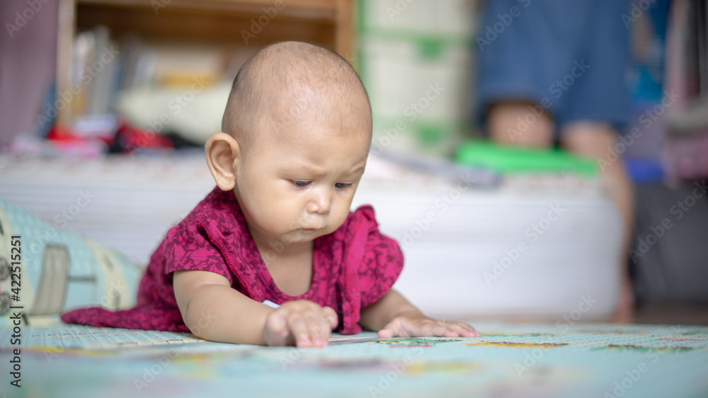 Asian Baby Girl who is 6 months old is rolling over and lifting her head up high and looking around Baby Development Asian Baby Girl who is 6 months old is rolling over and lifting her head up high and looking around Baby Development