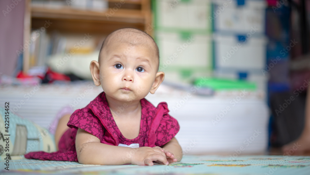 Asian Baby Girl who is 6 months old is rolling over and lifting her head up high and looking around Baby Development Asian Baby Girl who is 6 months old is rolling over and lifting her head up high and looking around Baby Development