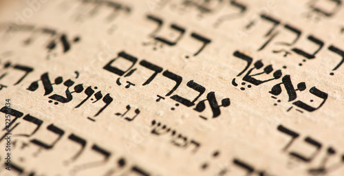 Closeup of hebrew word Abraham in Torah page. Selective focus. Banner.
