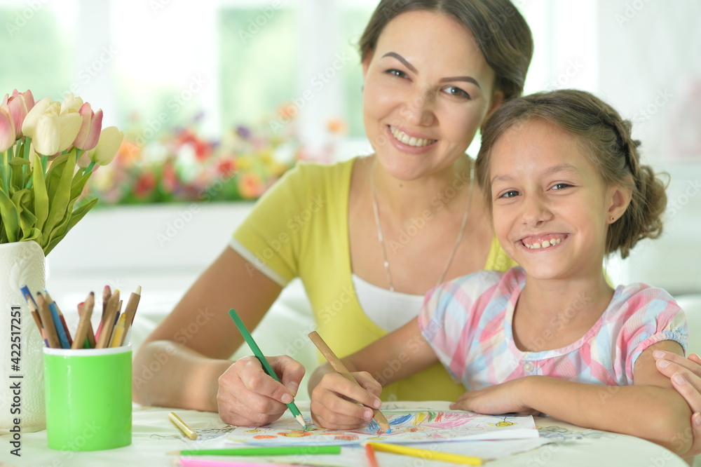 little cute girl with mother drawing at the table at home little cute girl with mother drawing at the table at home
