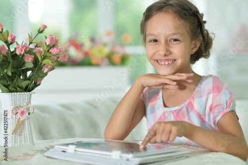 Portrait of Beautiful little girl with tableact pc