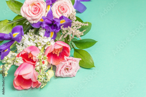 A beautiful bouquet of fresh flowers on a turquoise pastel background © FuzullHanum