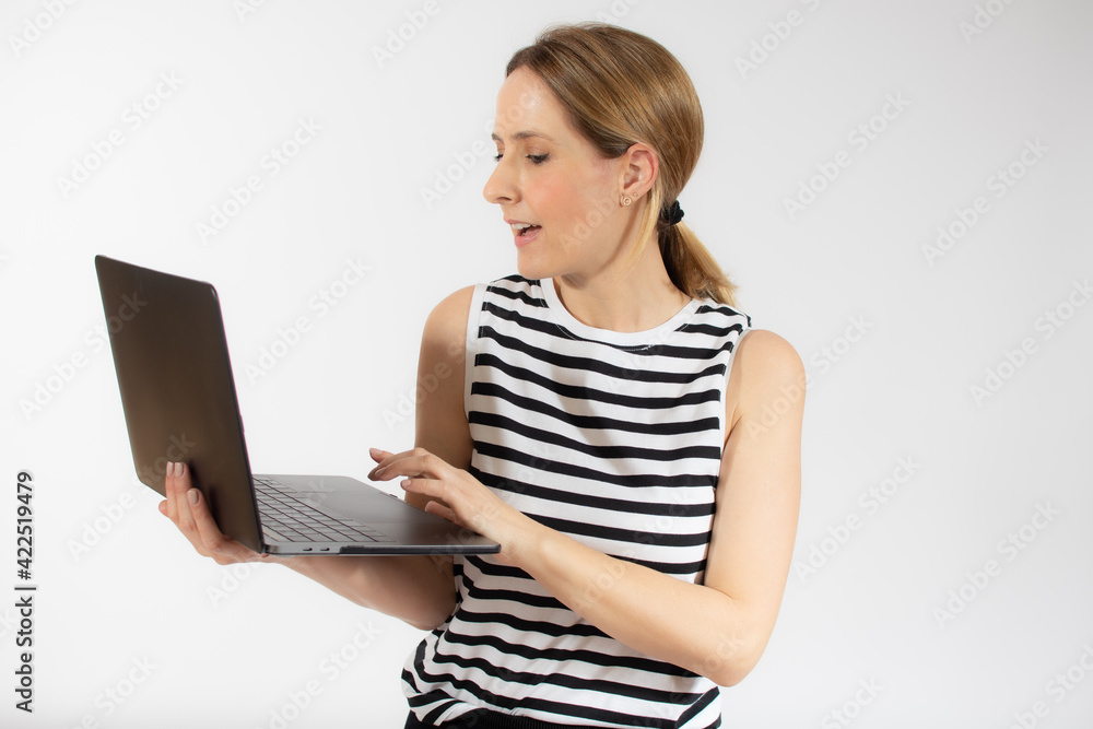 Young casual woman holding a laptop computer isolated over white background. Young casual woman holding a laptop computer isolated over white background.