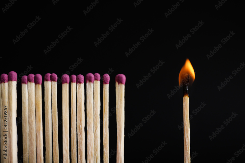 Burning match among others on black background Burning match among others on black background