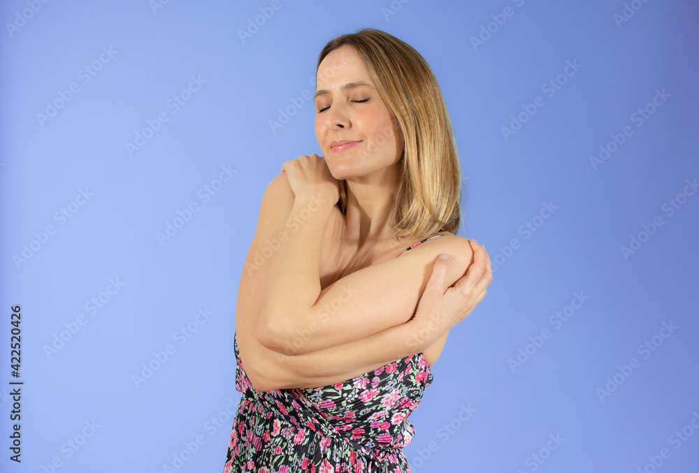 Portrait of a pretty young woman in summer dress hugging herself. Concept of selfish emotion. Portrait of a pretty young woman in summer dress hugging herself. Concept of selfish emotion.