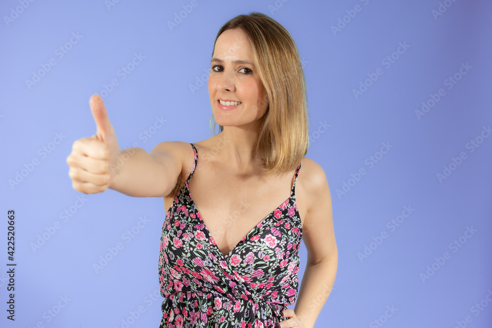 Close up portrait of smiling pretty young woman showing thumb up isolated over purple background Close up portrait of smiling pretty young woman showing thumb up isolated over purple background