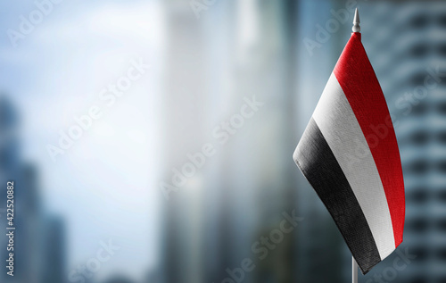 A small flag of Yemen on the background of a blurred background photo