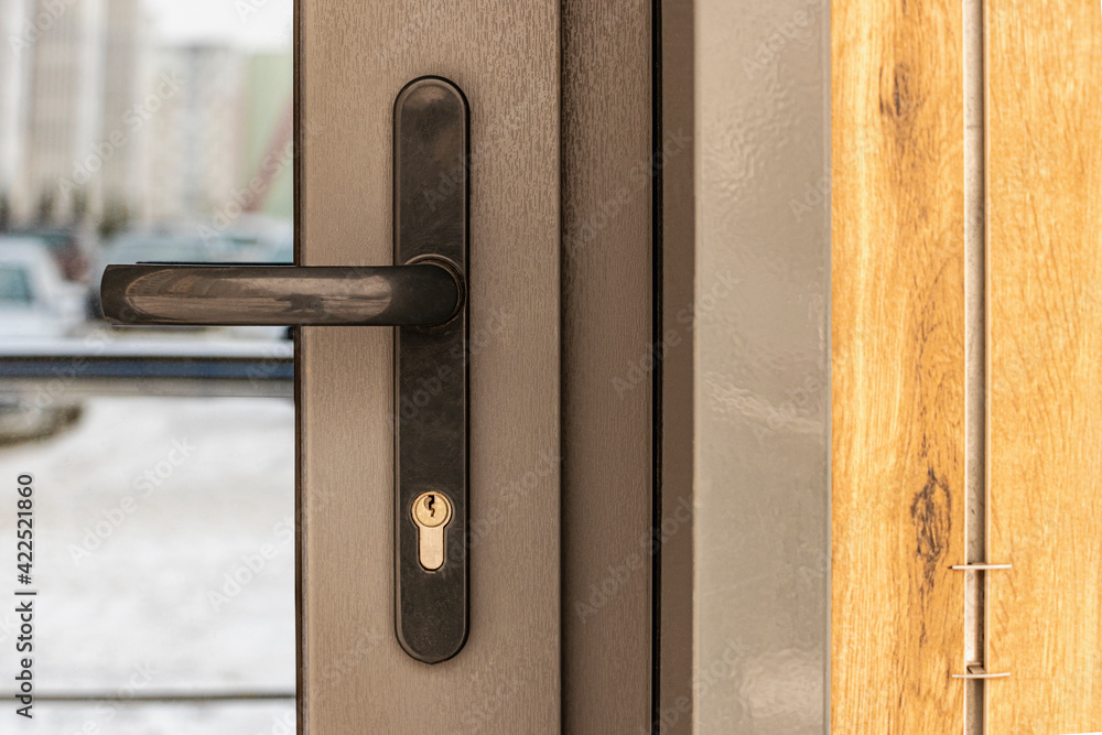 Hand holding a street glass front door. Double-glazed door. Entrance to the office building Hand holding a street glass front door. Double-glazed door. Entrance to the office building