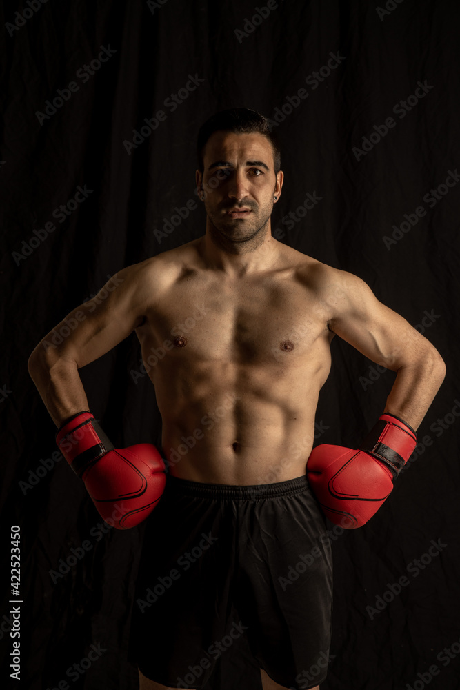 athlete man training with boxing gloves on black background