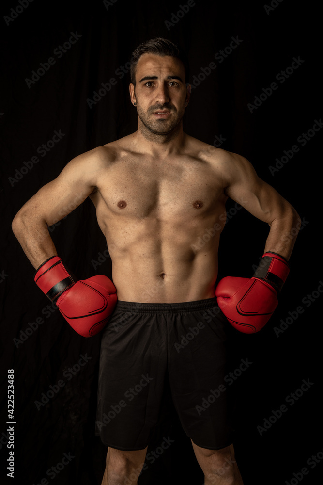 athlete man training with boxing gloves on black background