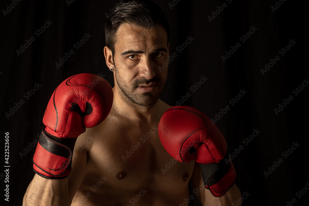athlete man training with boxing gloves on black background