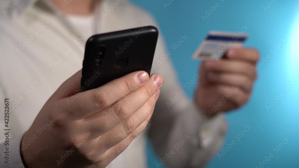 Man Enters Credit Card Information Into Smartphone. Online Shopping Concept. Man Enters Credit Card Information Into Smartphone. Online Shopping Concept.