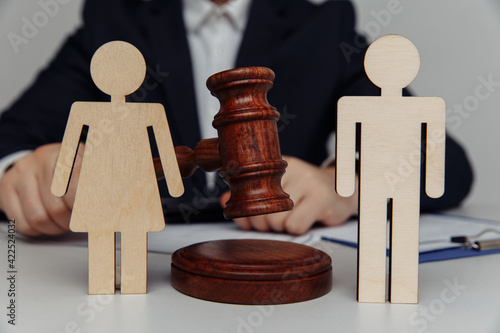 Photography Lawyer or counselor holds gavel behind of figures of young family, divorce and l