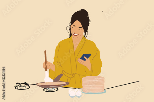 Pretty woman in a yellow bathrobe cooking pancakes on the pan on the gas stove while looking something on the phone. Sweet breakfast in the morning. Vector illustration.