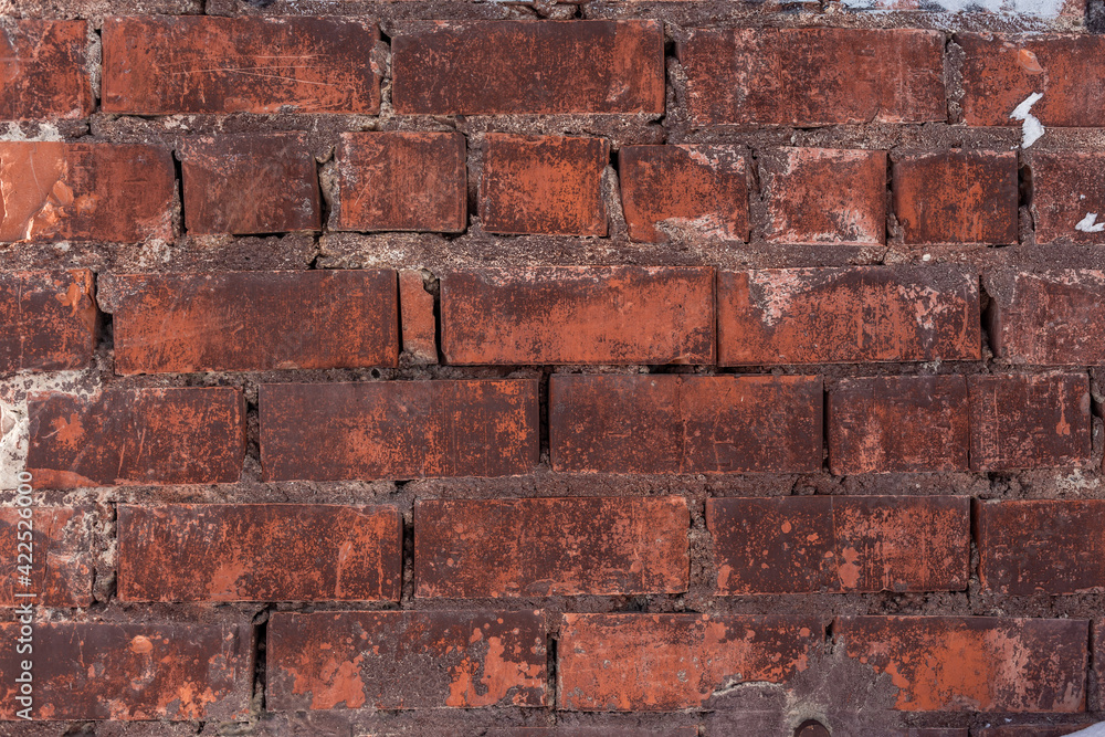 Aged red brick wall texture with traces of paint Aged red brick wall texture with traces of paint