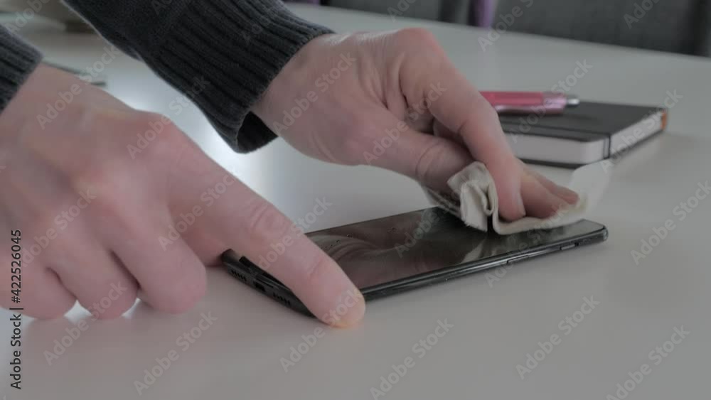 Man cleaning smartphone screen with alcohol. Man cleaning smartphone screen with alcohol.