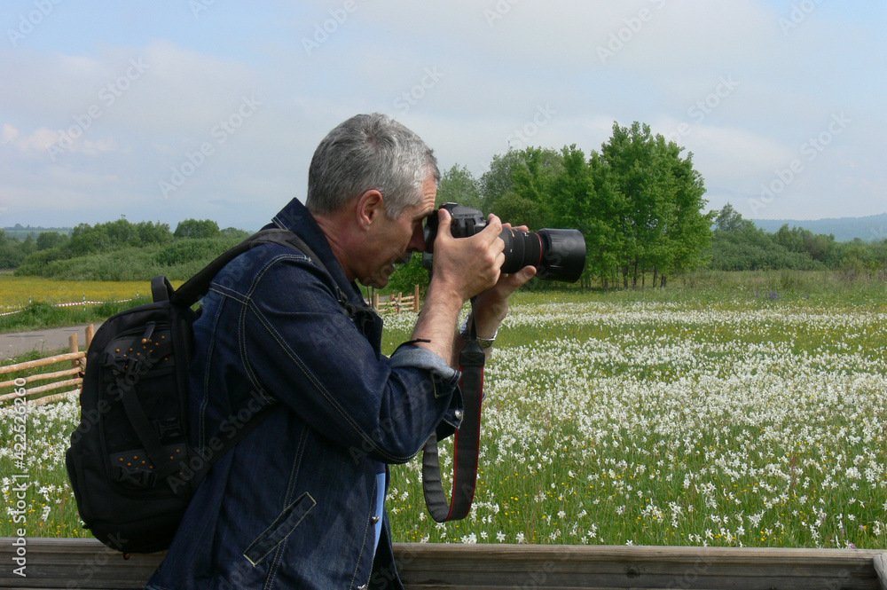 man photographing flowers