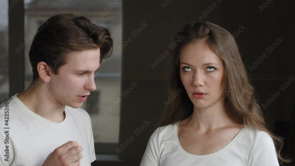 Portrait of couple of newlyweds, husband and wife quarreling at home, man aggressively speaks to offended woman crossing his arms in refusal, concept of family misunderstanding crisis in relationship Portrait of couple of newlyweds, husband and wife quarreling at home, man aggressively speaks to offended woman crossing his arms in refusal, concept of family misunderstanding crisis in relationship