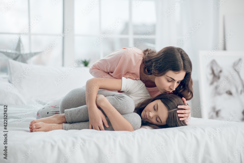 Girl with bent knees lying and mom worried Girl with bent knees lying and mom worried
