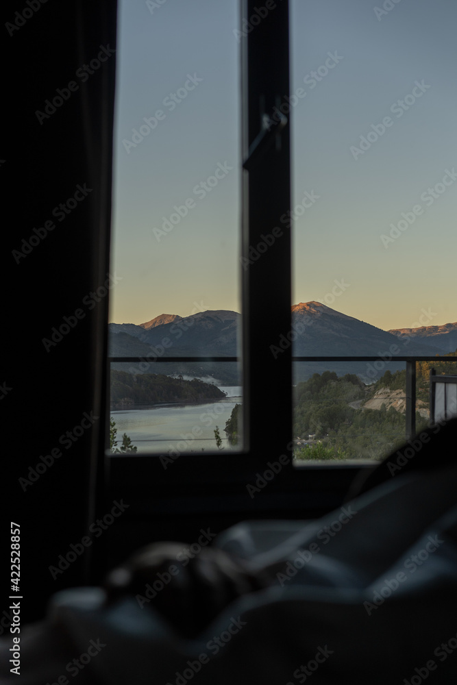 sunset landscape with lake and mountains from windows