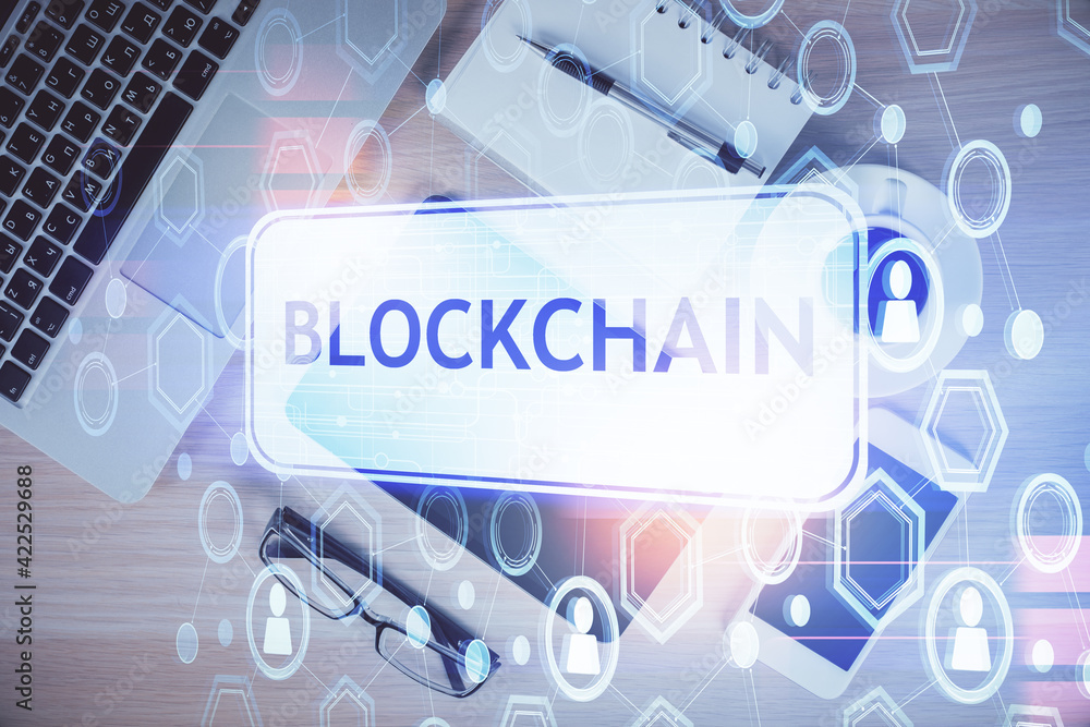 Double exposure of blockchain theme hologram over table with phone. Top view. Crypto technology concept. Double exposure of blockchain theme hologram over table with phone. Top view. Crypto technology concept.