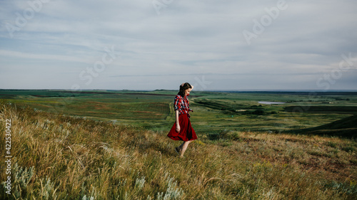 girl in a red skirt enjoys the summer in the field