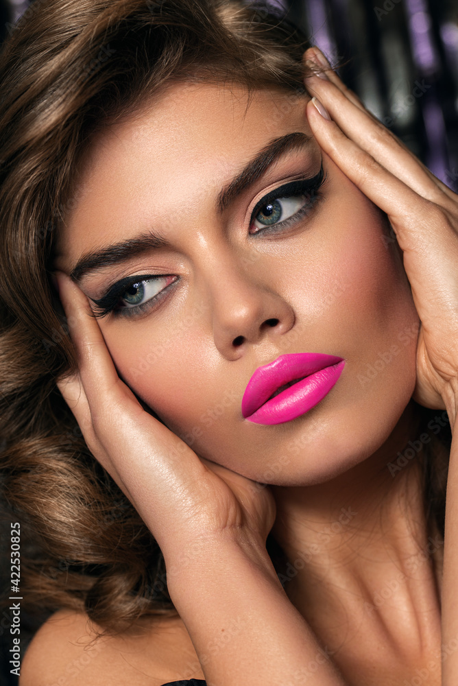 Obraz premium Close up portrait of young beautiful model with clean healthy skin and possible make-up. emphasis on lips, lipstick. Classic makeup with arrows on the eyes. Hollywood diva.