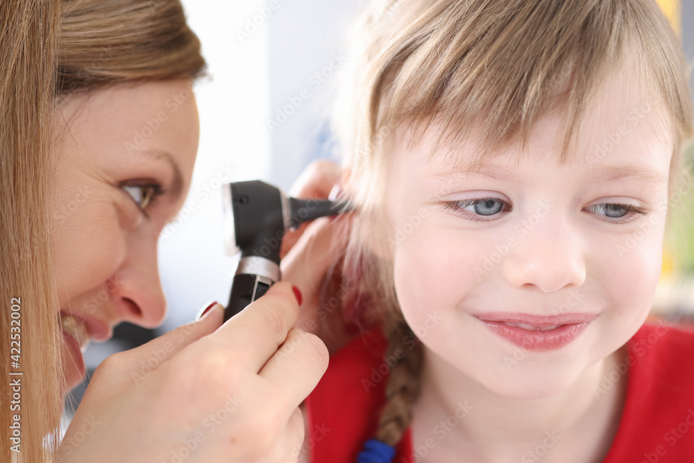 Otorhinolaryngologist looking at sore ear of little girl Otorhinolaryngologist looking at sore ear of little girl