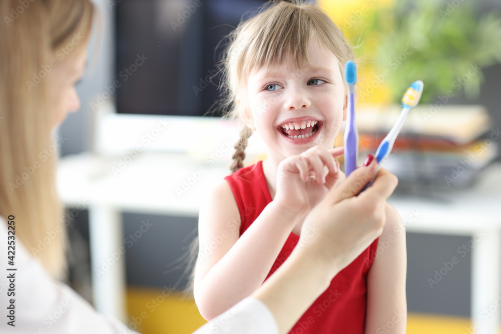 Little girl choosing toothbrush at dentists office Little girl choosing toothbrush at dentists office