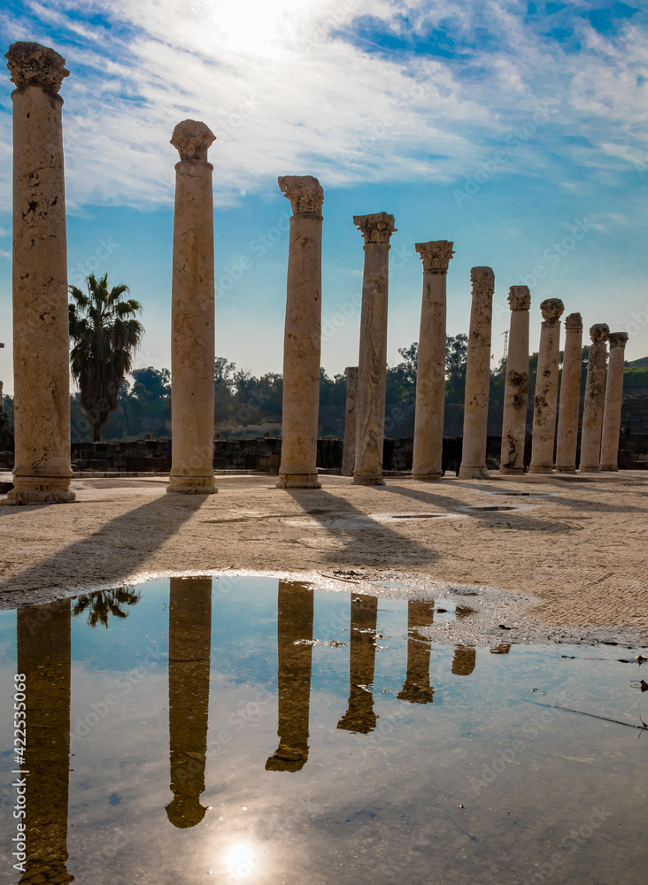 Ancient Roman columns reflect in puddle at Bet She'an, Israel