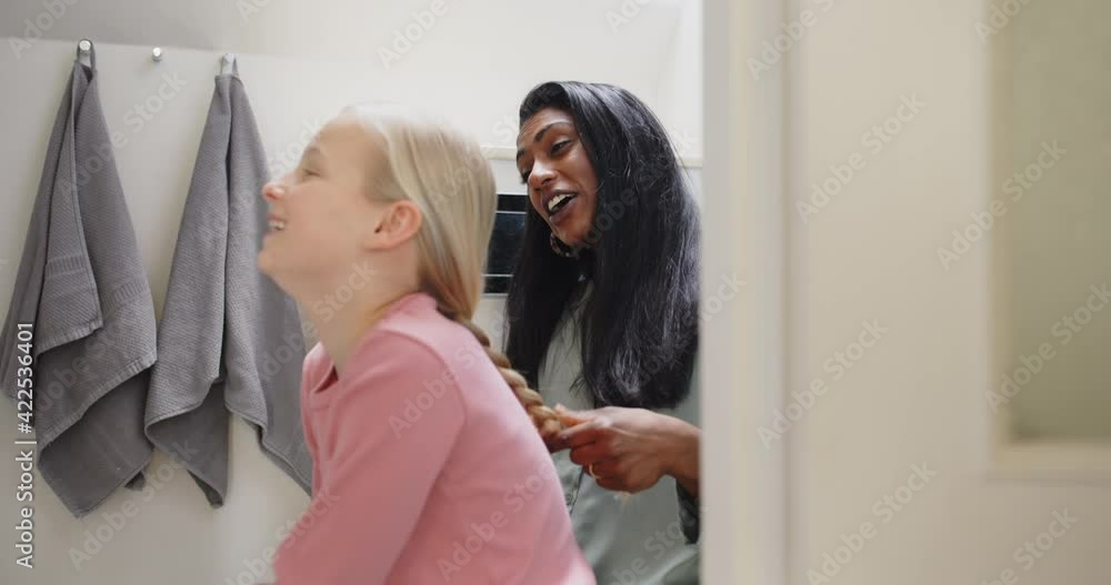 Mother braiding her girl's blonde hair in the
morning Mother braiding her girl's blonde hair in the
morning