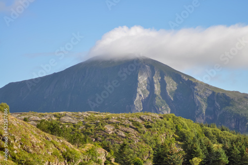 White cloud on top of the mountain in Helgeland archipelago in the Norwegian sea 