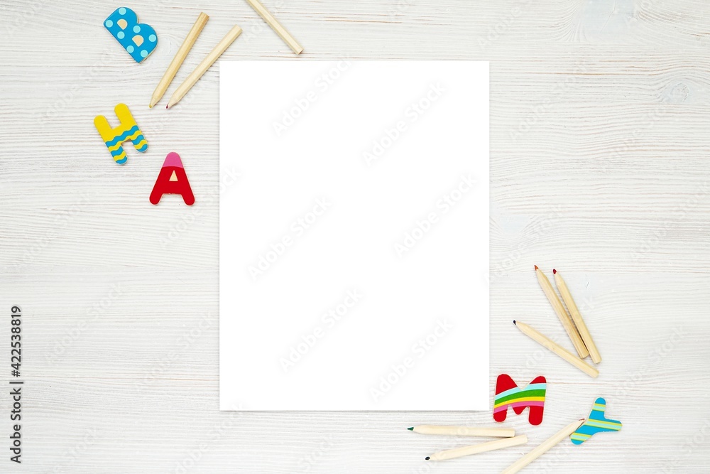 Blank vertical paper sheet, coloring page, kids worksheet mockup, flat lay  with pencils and colorful letters. Stock Photo