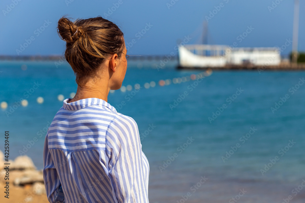 Woman enjoying freedom. Standing arms outstretched back and enjoy life on the beach at sea under sunlight sky. Woman enjoying freedom. Standing arms outstretched back and enjoy life on the beach at sea under sunlight sky.