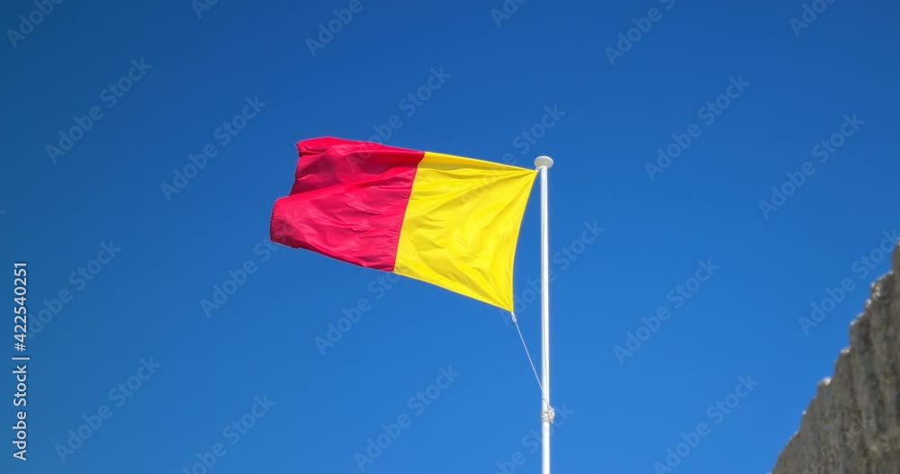 Red And Yellow Flag Waving In The Strong Wind. Closeup View - DCi 4K Resolution Red And Yellow Flag Waving In The Strong Wind. Closeup View - DCi 4K Resolution