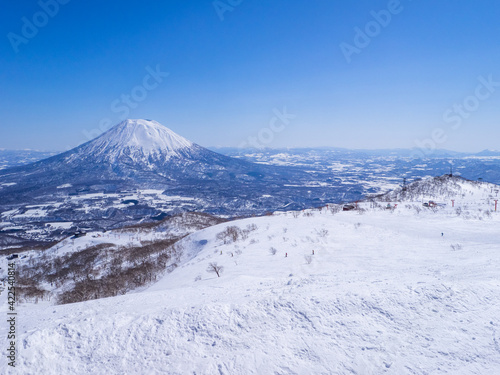 Looking at ski resort and snowy volcano on a clear day in early spring (Niseko Mt.Resort Grand Hirafu, Hokkaido, Japan)