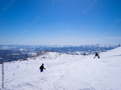 People skiing on a clear day in early spring (Niseko Mt.Resort Grand Hirafu, Hokkaido, Japan)