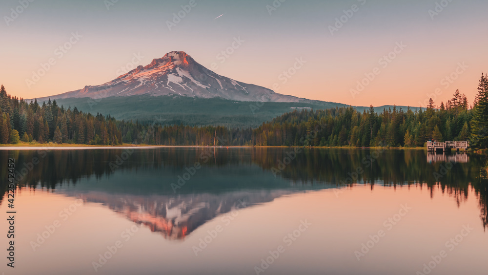 Panoramic landscape of the gorgeous sunset glow on the peak of Mount Hood and the perfect glass reflections over Lake Trillium in Mount Hood National Forest, Oregon, USA.