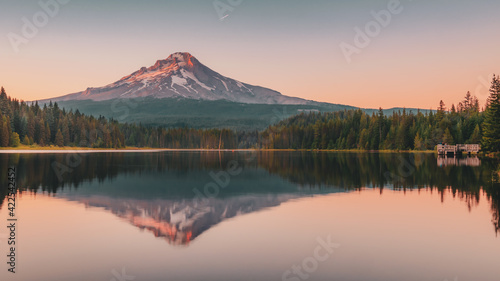 Panoramic landscape of the gorgeous sunset glow on the peak of Mount Hood and the perfect glass reflections over Lake Trillium in Mount Hood National Forest, Oregon, USA.