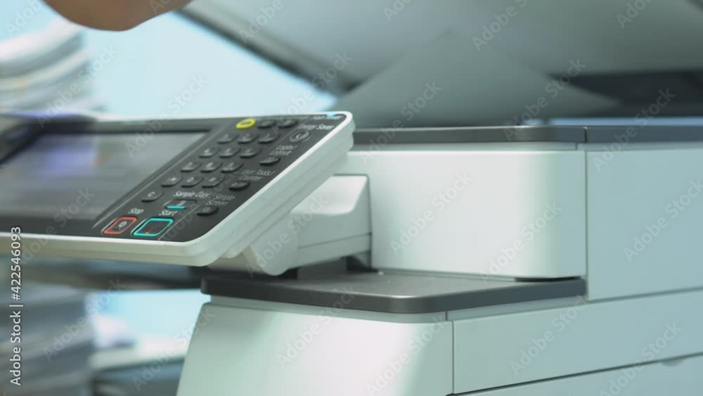 Hand of woman is using a photocopier to copy documents.